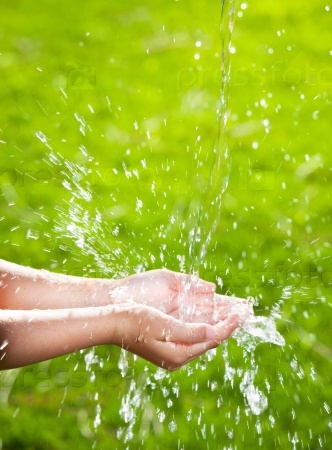 Stream of clean water pouring into children\'s hands.