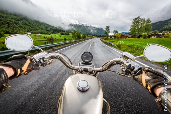 Biker rides a motorcycle in the rain. First-person view.