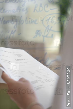 Medical doctor writing patient test results on transparent board to diagnose , out of focus