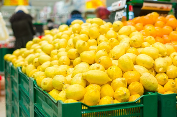 Bunch of lemons and oranges on boxes in supermarket