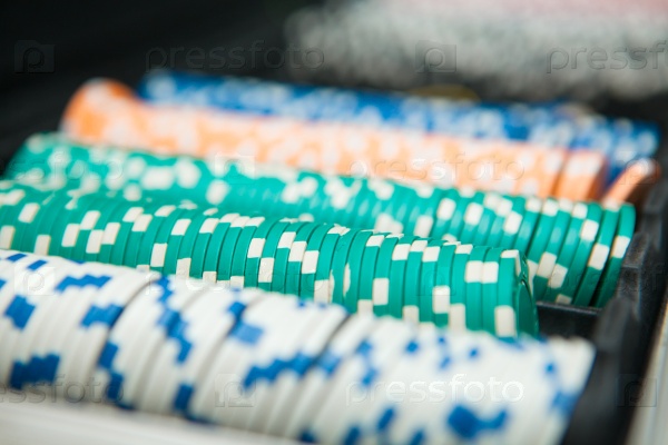 Poker Chips on a gaming table with dramatic lighting.
