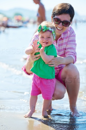 mom and baby on beach have fun