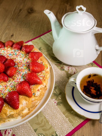 Honey cake with strawberry on top and tea