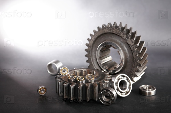 Machinery concept. Abstract composition with few ball bearings near big gears, stock photo