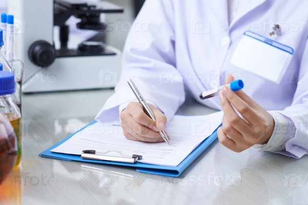 Medical worker writing results of blood test