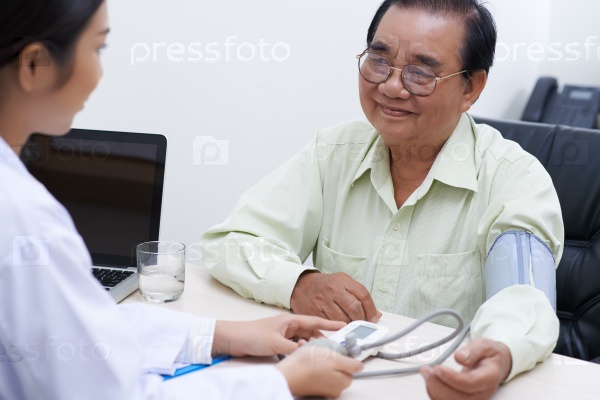 Nurse measuring blood pressure of patient