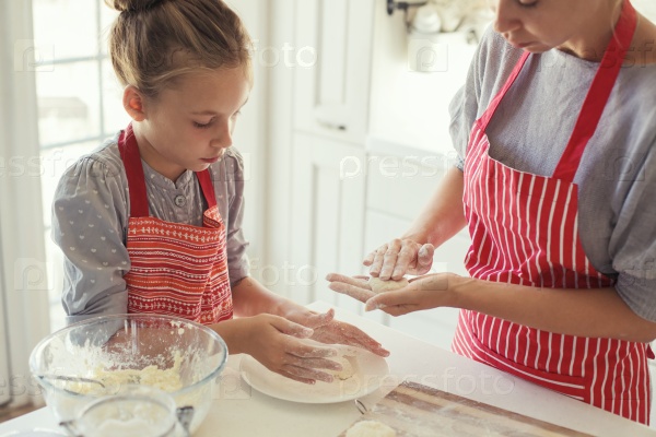 Mom with her 9 years old daughter are cooking in the kitchen to Mothers day, lifestyle photo series in bright home interior
