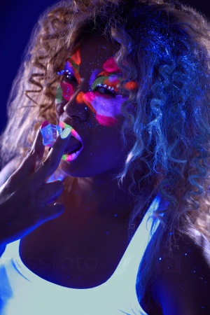 Beautiful curly girl posing in ultraviolet light