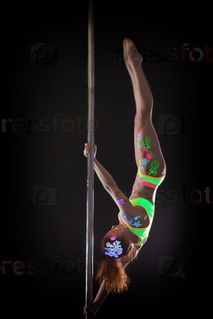 Sporty young girl dancing on pole upside down