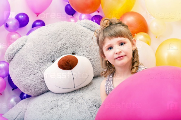 Portrait of blue-eyed girl with big teddy bear