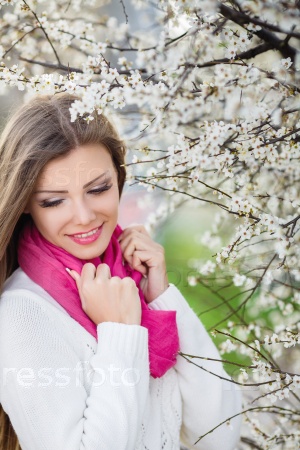 portrait of young brunette in the spring blooming garden