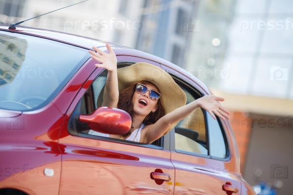 happy young woman in car driving on the road. Summer car travel freedom woman  with arms raised up cheerful and happy. Summer road trip traveler concept.