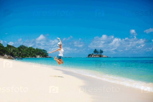 Summer,laughing woman jumping on the beach