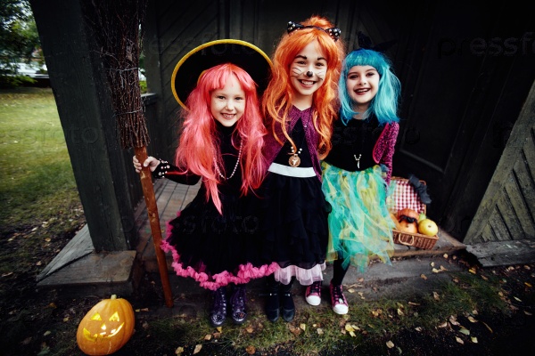 Halloween witches looking at camera by haunted house