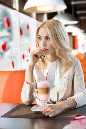 Very beautiful sad young woman, sit in Cafe and drink coffee- cocktail, vertical portrait