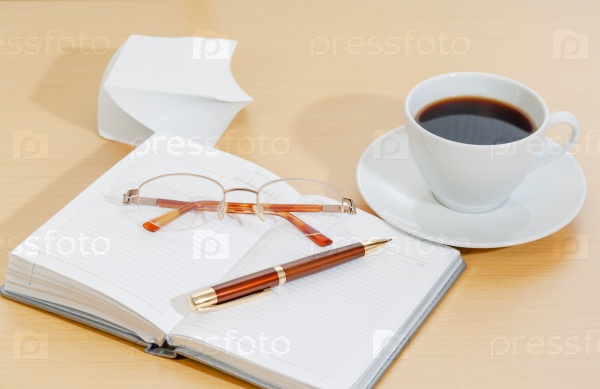 Image of planner , coffee cup pen and glasses