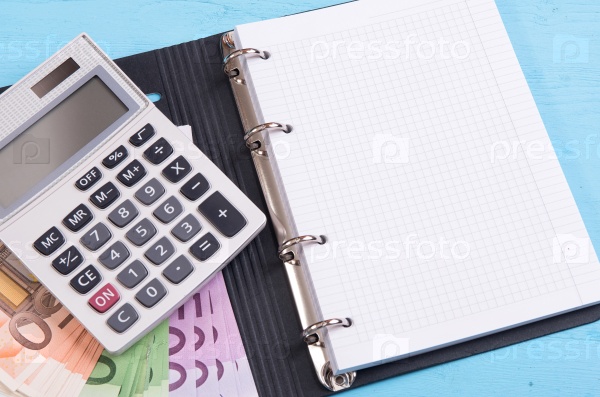 money, calculator and blank notepad