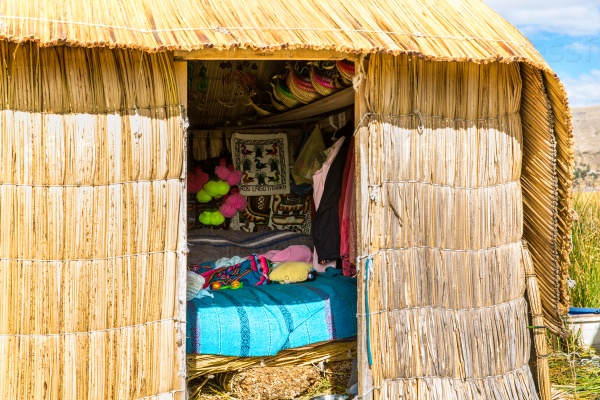 Thatched home on Floating  Islands on Lake Titicaca Puno, Peru, South America. Dense root that plants Khili interweave form natural layer about one to two meters thick that support islands