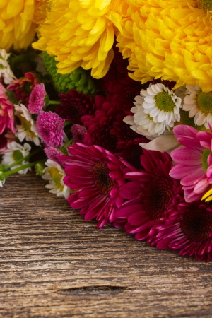 Bunch of fresh pink and yellow mum flowers on wooden table