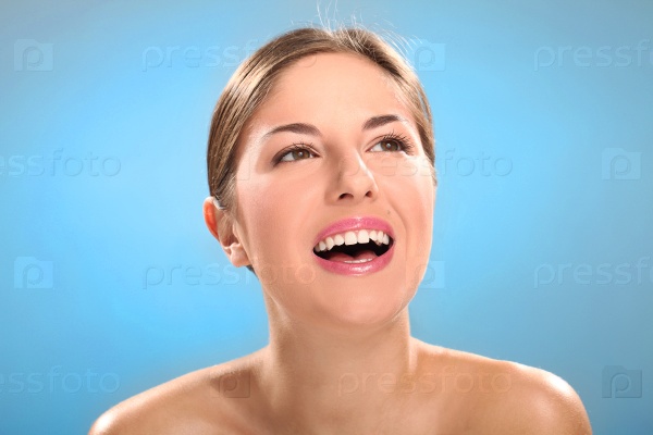 Caucasian woman with natural make-up laughing isolated over blue background, stock photo