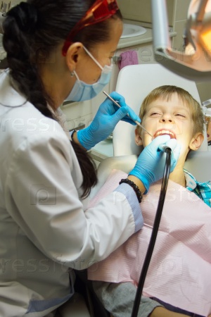 Close-up boy opening his mouth wide during inspection of oral cavity by dentist