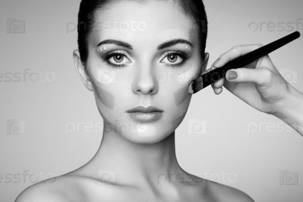 Makeup artist applies skintone. Beautiful woman face. Perfect makeup. Skincare foundation. Black and white, stock photo