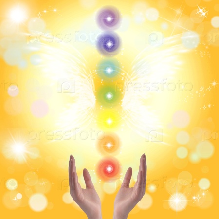 Healing hands and seven chakras on a sky background with rainbow, stock photo
