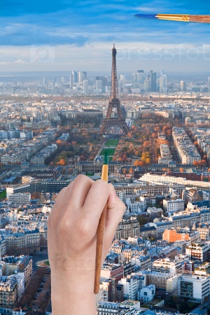 travel concept - hand with paintbrush paints in green colour Champ de Mars near Eiffel tower in Paris city, France