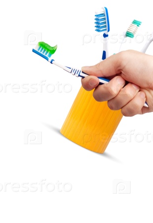 Toothbrush and toothpaste in a hand isolated on white background