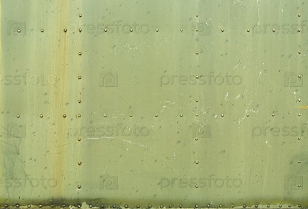 Abstract painted matte green metal background with rivets. Riveted military green texture.