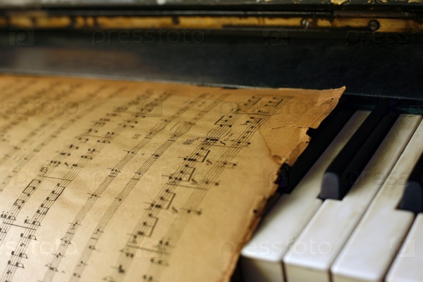 The keyboard of the piano and old notes, stock photo