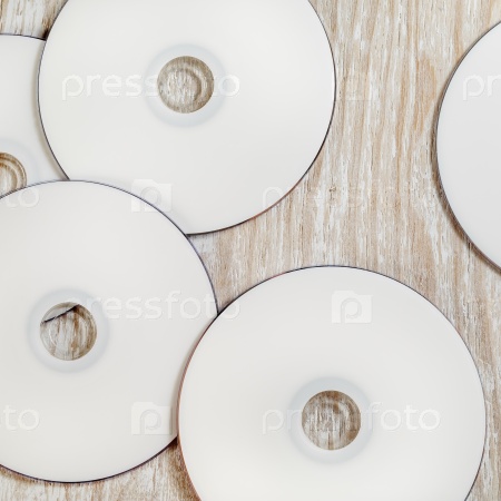 Blank printable CD and DVD on light wooden background. Top view.
