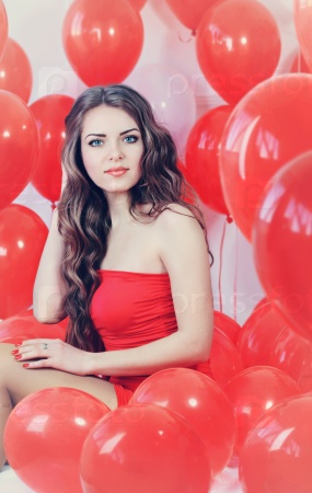 Beautiful long-haired woman with big red balloons