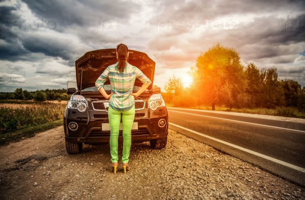 Woman on the road near the car. Damage to vehicle problems on the road, stock photo