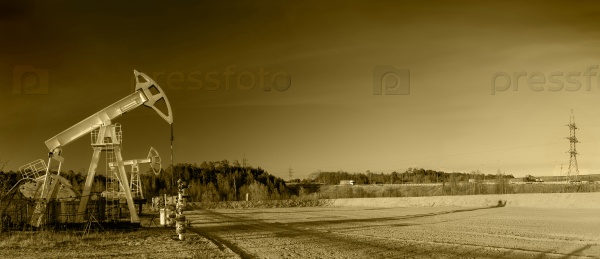 Pump jack group and wellheads. Extraction of oil. Toned, stock photo