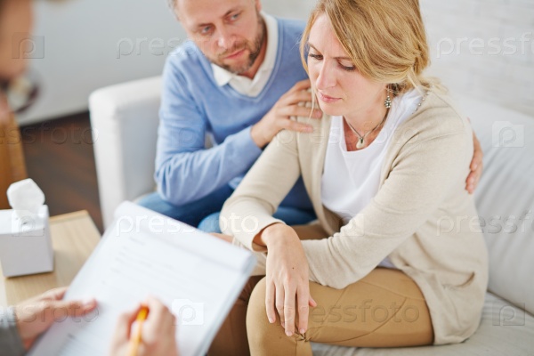 Unhappy woman and her anxious husband visiting psychologist together