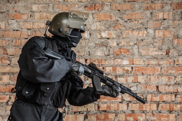 Special forces operator in black uniform and bulletproof