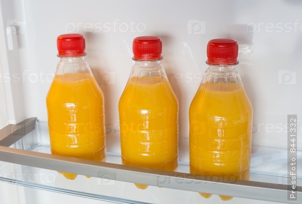 Open fridge filled with orange juice, stock photo