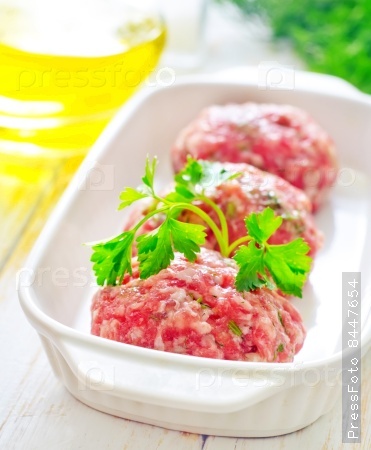 Raw meat balls in the white bowl