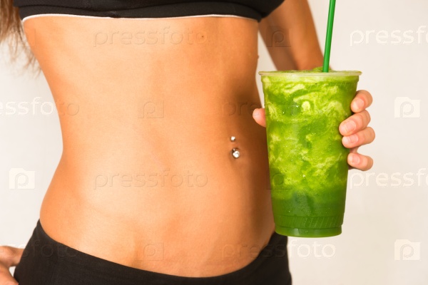 Woman holds Green Fruit Smoothie Waist Level Showing Healthy Slender Body