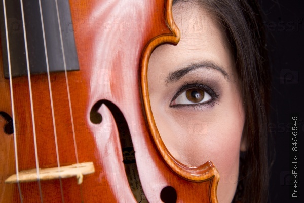 A Woman\'s Face with eye looking up Behind Violin Stringed Instrument