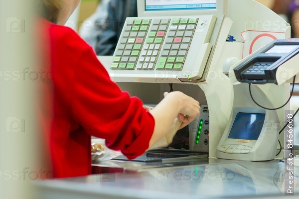 Cash-desk with cashier and terminal in supermarket. Serve customer