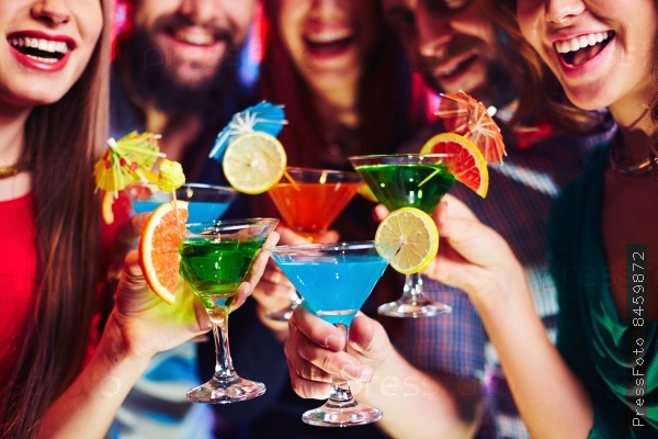 Cheerful friends with citrus cocktails cheering at party, stock photo