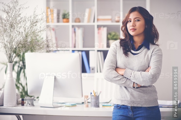 Confident female entrepreneur standing in her office