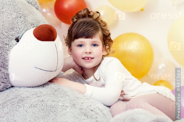 Adorable girl posing lying on teddy bear