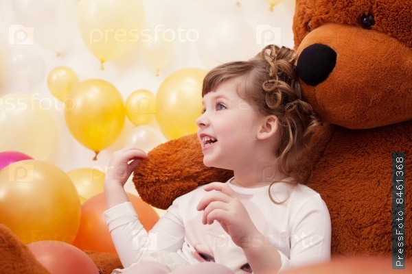 Joyful little girl posing hugging plush bear
