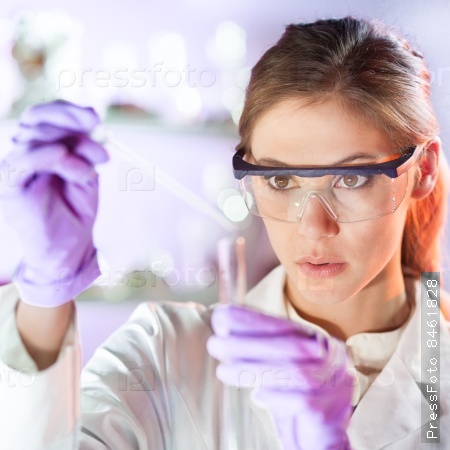 Life scientists researching in laboratory. Focused female life science professional pipetting solution into the glass cuvette. Lens focus on researcher\'s eyes. Healthcare and biotechnology concept, stock photo