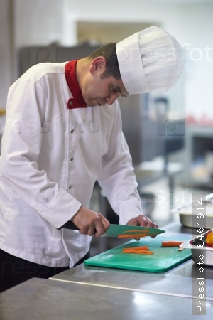 chef in hotel kitchen  slice  vegetables with knife and prepare food