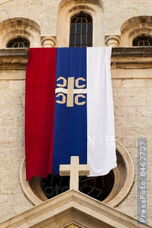 the flag of the Serbian orthodox church being on ancient church in the city of Kotor, Montenegro