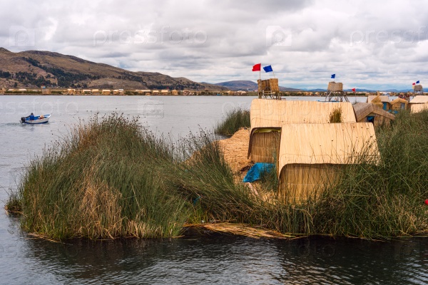 Thatched home on Floating Islands on Lake Titicaca, Puno, Peru, South America. Dense root that plants Khili interweave form natural layer about one to two meters thick that support islands